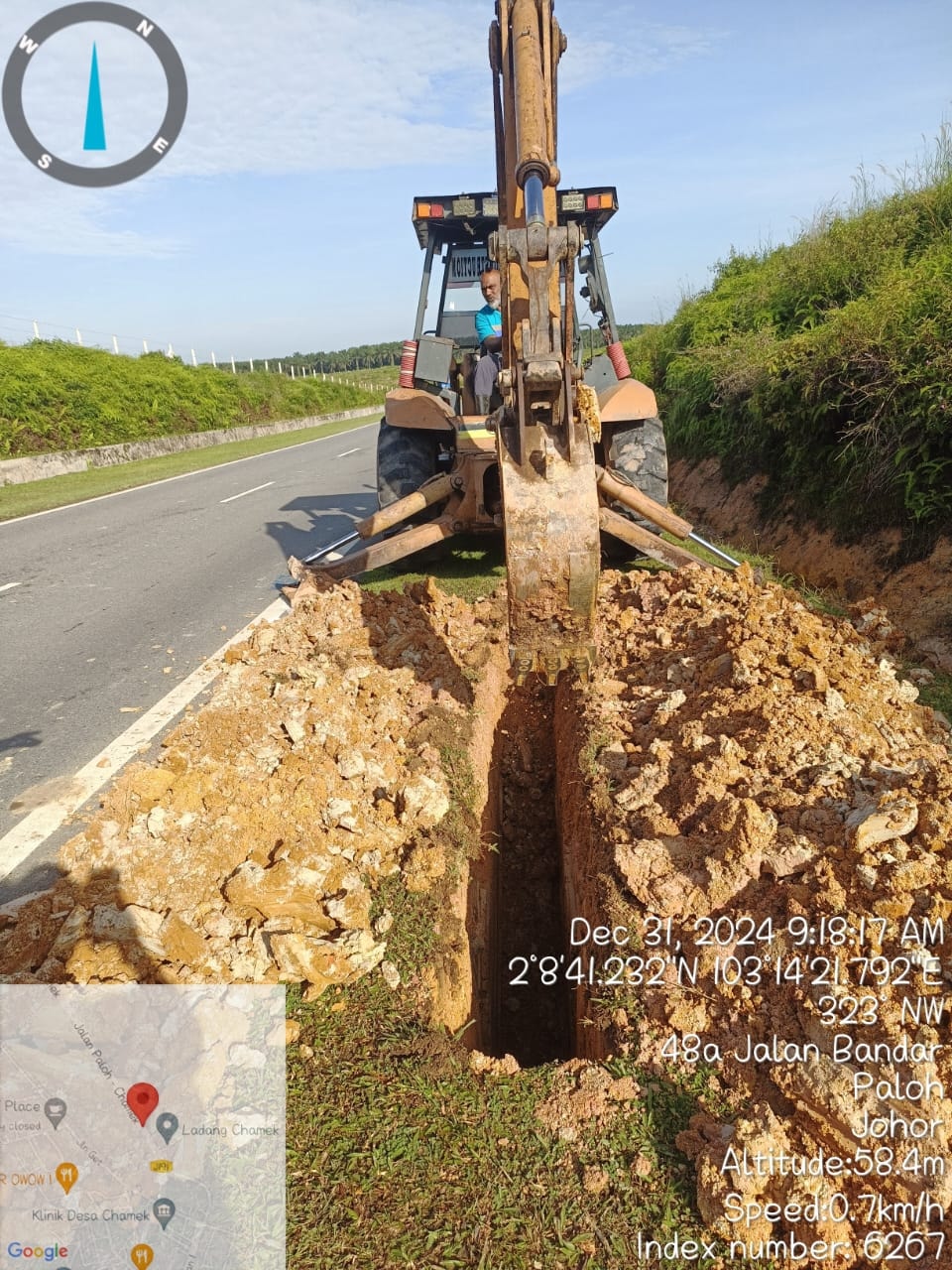 Excavator digging roadside trench at 48a Jalan Bandar, Paloh, Johor (31 December 2024).