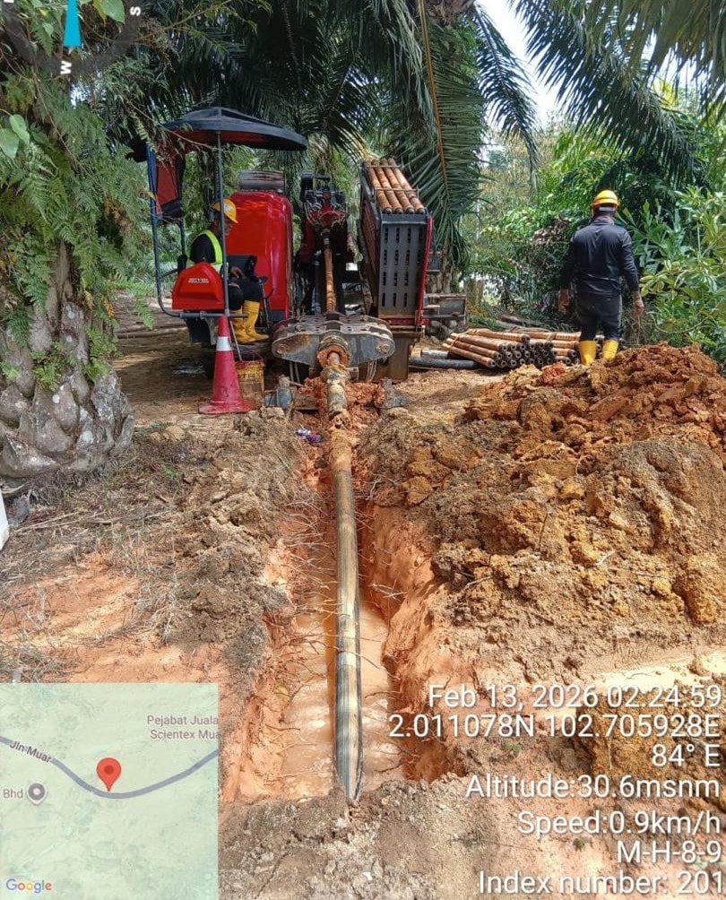 Excavator digging roadside trench, 48a Jalan Bandar, Paloh, Johor (31 December 2024). GPS: 2°8'41.232"N 103°14'21.792"E.
